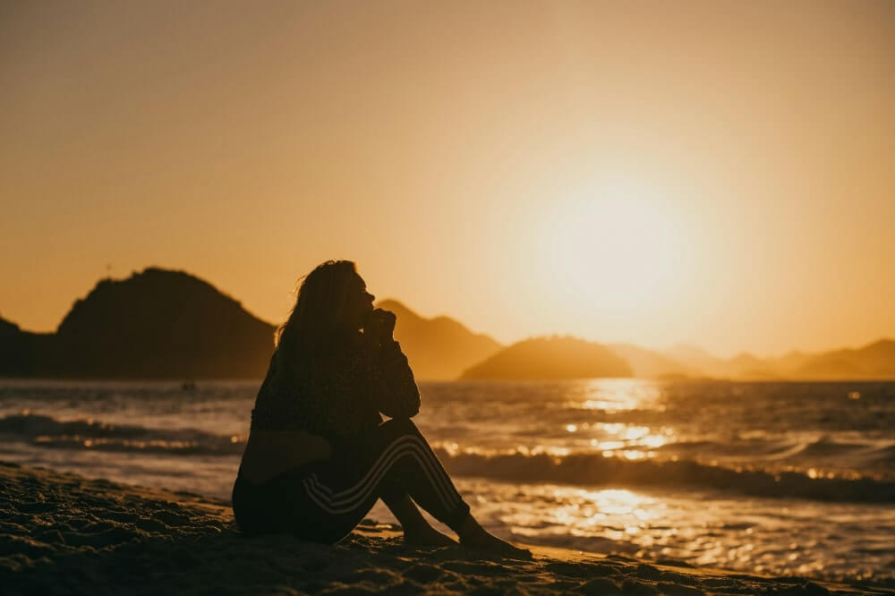 海辺で悲しむ女性